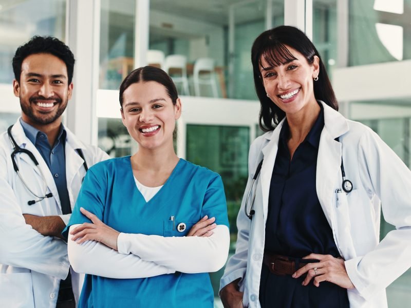 Portrait, group and doctors with smile, hospital and confident for career growth and medical service. Happy, healthcare professionals and people with pride for unity, team and colleagues in clinic