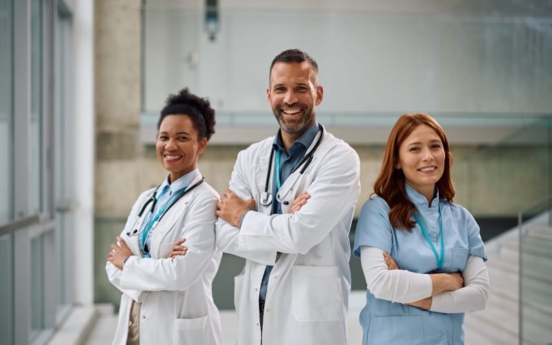Multiracial group of doctors standing with crossed arms at the hospital and looking at camera.